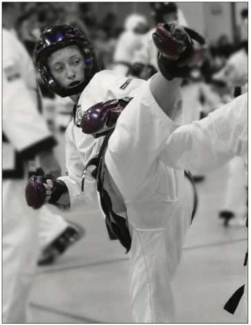 Instructor Alyssa Folkwie spars and does a hook kick.