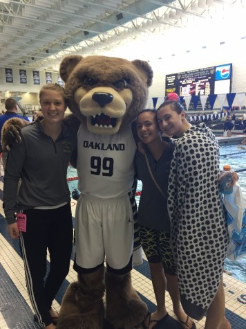 Sophomore Sam Villiani poses for a picture with the Oakland University mascot and fellow swimmers Hannah Mattes and Angelina Cavaliere.