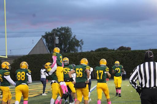 LIFTING SPIRITS | Players celebrate after a touchdown against Fitzgerald during their pink out game. Senior captain Kyle Armbruster is most proud in these moments when their hard work is rewarded. “Fixing the mistakes we made in games and not seeing the same mistakes twice is definitely something I want to see every day,” Armbruster said. 
