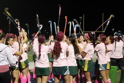 STICKS UP, SPIRITS UP | With a cancer awareness and rival game all in one, spirits were high on the field for the varsity field hockey team. Varsity coach Sara Gentile admires the player’s undeniable energy. “They had their hair dyed and custom made jerseys [on] so there was a positive light to the game while still keeping it competitive.”

